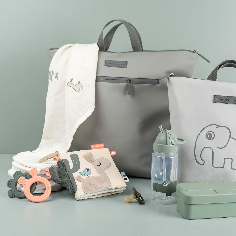 Hoitolaukkuja, leluja ja pillipullo pöydällä.