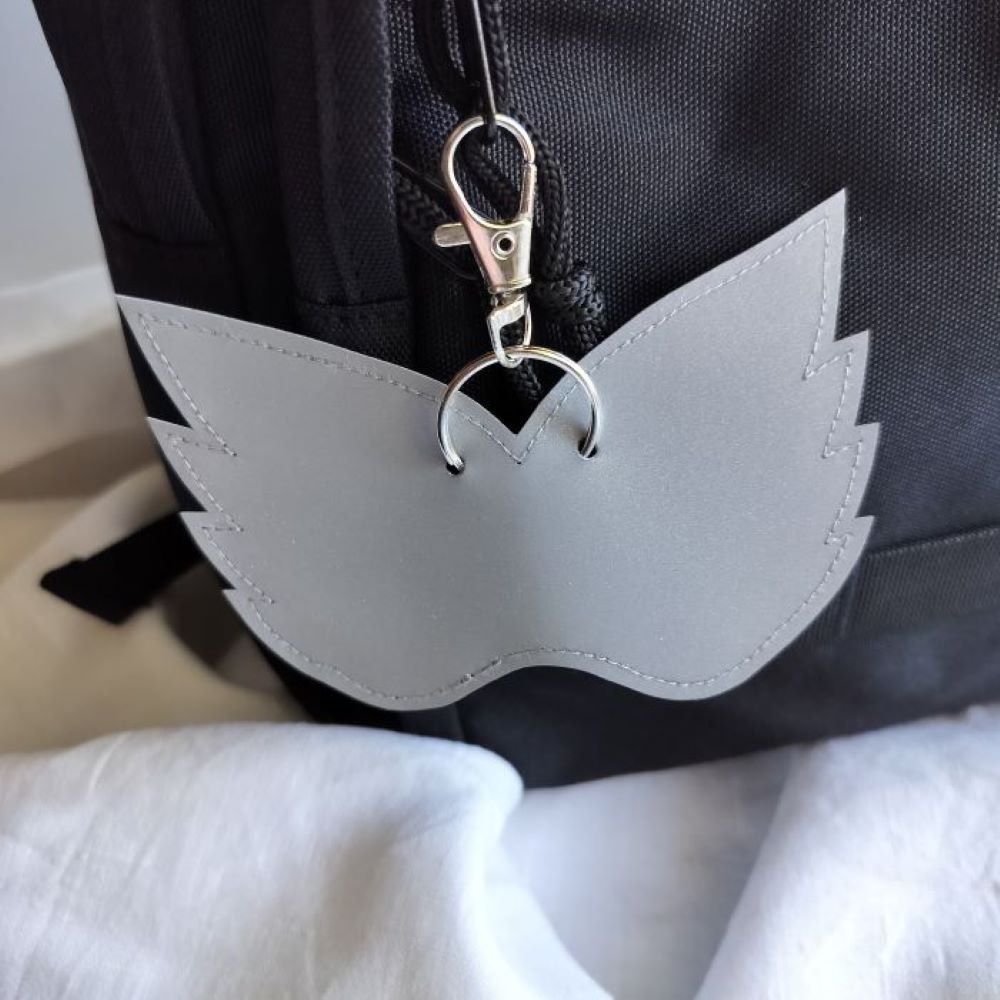 Suojelus Design laukkuheijastin repussa, enkelinsiivet.